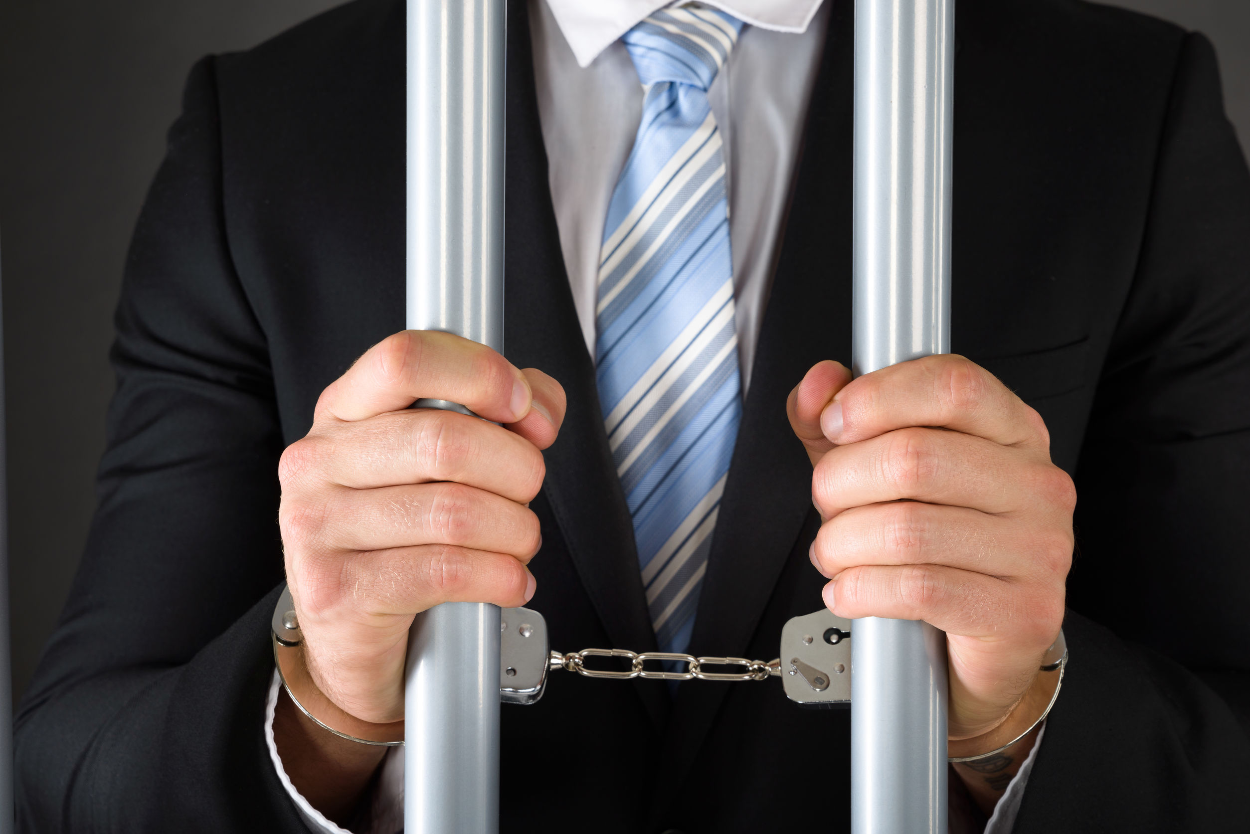 Handcuffed Businessman Holding Bars