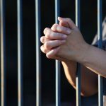 hand praying in jail